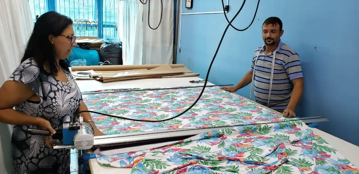 The Mar Egeu team cutting patterned swimwear fabric